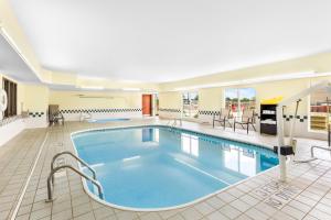 a pool in a hotel room with tables and chairs at Comfort Inn in Marion