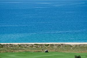 a vehicle parked on a golf course next to the ocean at Palmares Beach House Hotel - Adults Only in Lagos