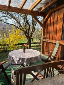 a table and chairs on a porch with a tree at Ferienwohnung Löffel-Lodge in Heimbach