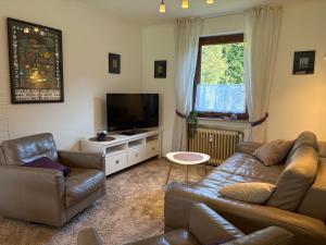 a living room with a couch and a flat screen tv at Ferienwohnung Löffel-Lodge in Heimbach