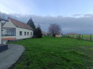 a house with a grassy yard next to a building at Gîte du Trempal in Audruicq