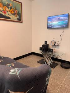 a room with a desk and a tv on a wall at Cómodo apartamento en el centro de caraca in Caracas