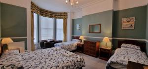 a hotel room with two beds and a window at The Portland Hotel in Folkestone +36 photos
