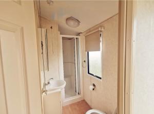 a small bathroom with a sink and a toilet at VJ Plum a 2 bed 6 berth luxury static caravan, bedding Included, on Coral Beach in Ingoldmells in Ingoldmells