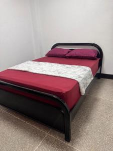 a bed with red and white sheets on it at Cómodo apartamento en el centro de caraca in Caracas