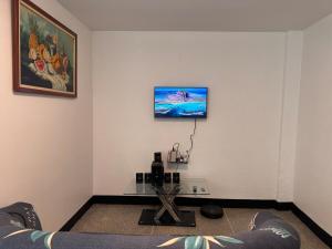 a living room with a couch and a tv on the wall at Cómodo apartamento en el centro de caraca in Caracas +7 photos