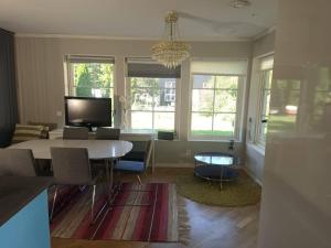 a living room with a table and chairs and a chandelier at Workers Stay - Temporary House Umeå in Umeå