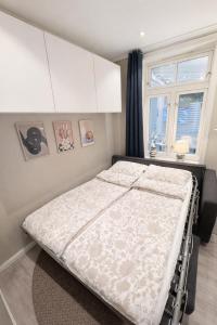 a large bed in a bedroom with a window at Liten studioleilighet meget sentralt i sentrum, 3 minutter fra torget in Trondheim