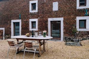 a table and chairs in front of a brick building at Gîte Grise Pierre in Herve