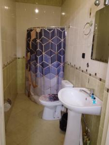 a bathroom with a toilet and a sink at Bodomzor Family Hotel in Salor Bekati