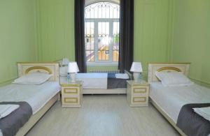 two beds in a room with green walls at Bodomzor Family Hotel in Salor Bekati