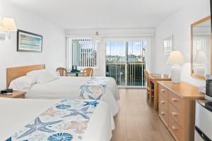a hotel room with two beds and a balcony at The Ocracoke Harbor Inn in Ocracoke