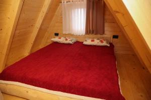 a bedroom with a large red bed in a attic at Podostroška želja in Danilovgrad