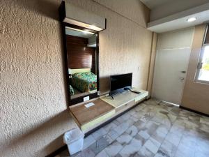 a bedroom with a mirror and a bed in a room at Hotel De Cima Beach Club in Mazatlán