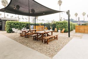 a group of picnic tables under a black canopy at The Green Room Hotel in Oceanside