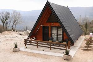 a small wooden cabin with a black roof at Podostroška želja in Danilovgrad