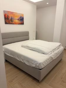 a bed in a bedroom with a painting on the wall at Bilocale accogliente in centro Aprica in Aprica