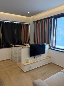 a living room with a flat screen tv and curtains at Bilocale accogliente in centro Aprica in Aprica