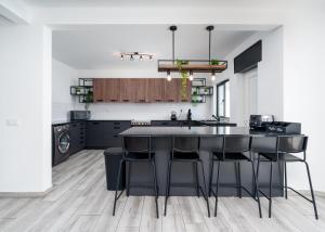 a kitchen with black cabinets and a kitchen island with bar stools at Villa Garden - 22 Guests - 2 Pools in Albufeira
