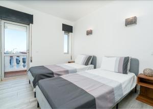 two beds in a room with a window at Villa Garden - 22 Guests - 2 Pools in Albufeira +101 photos