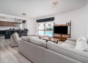 a living room with two couches and a television at Villa Garden - 22 Guests - 2 Pools in Albufeira