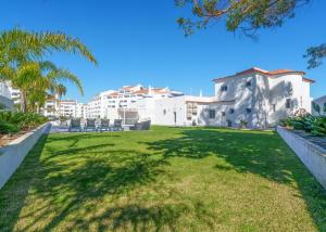 a lawn in front of a building with palm trees at Villa Garden - 22 Guests - 2 Pools in Albufeira