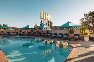 a pool with chairs and umbrellas at a hotel at Skyview Los Alamos - 21 & Over Pool in Los Alamos