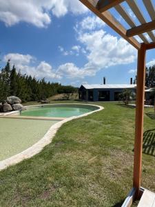 a view of a swimming pool with a building in the background at Buenos Vientos Casa de Campo in Maldonado