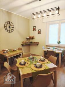 a dining room with tables and chairs and a clock on the wall at Ca' Gioel in Sedrina