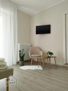 a living room with a chair and a tv on a wall at Ca' Gioel in Sedrina