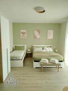 a bedroom with two beds and a bench in it at Ca' Gioel in Sedrina