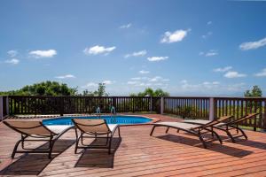a deck with two chairs and a swimming pool at Villa O'Bed in Grand-Bourg