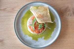a plate of food with a tortilla in a green sauce at Hótel Laxá in Myvatn
