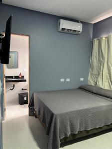 a bedroom with a bed with a blue wall at Hotel e Restaurante Santa Isabel in São Raimundo Nonato