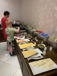 a young boy standing in a kitchen preparing food at Bodomzor Family Hotel in Salor Bekati +7 photos