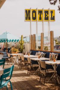 a patio with tables and chairs and a motel sign at Skyview Los Alamos - 21 & Over Pool in Los Alamos +31 photos