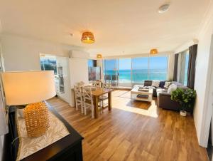a living room with a couch and a table at Absolute Beachfront Ocean Balcony Heated Pool in Gold Coast +23 photos