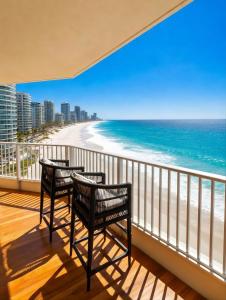 a balcony with two chairs and the beach at Absolute Beachfront Ocean Balcony Heated Pool in Gold Coast