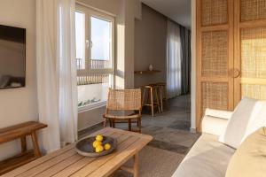 a living room with a table with a bowl of fruit on it at Cavo Dio 2 - Beachfront Bliss - Cozy Apt Pool Sunsets in Dhiminión