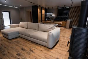 a living room with a white couch and a kitchen at Goldhill villa in Yaremche
