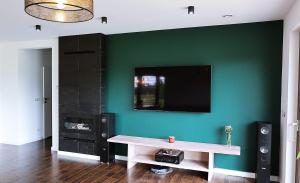 a living room with a table and a tv on a wall at Dom Mazury in Langendorf +6 photos
