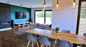 a living room with a wooden table and chairs at Dom Mazury in Langendorf