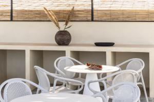 a white table and chairs with a bowl of fruit on it at Cavo Dio 2 - Beachfront Bliss - Cozy Apt Pool Sunsets in Dhiminión