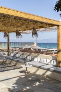 a pavilion with couches and tables on the beach at Cavo Dio 2 - Beachfront Bliss - Cozy Apt Pool Sunsets in Dhiminión +16 photos