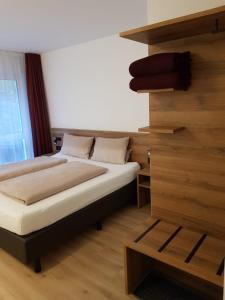 a bedroom with a bed and a wooden wall at Gestütsgasthof Marbach in Marbach