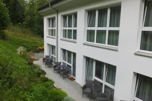 a white building with chairs in front of it at Gestütsgasthof Marbach in Marbach