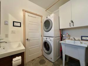 a bathroom with a washing machine and a sink at Le Chalet Waterfront Studio Suite, View, Patio, Kitchen in Ucluelet