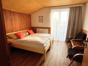 a bedroom with a bed and a large window at Penzion U Kuboňů in Volary