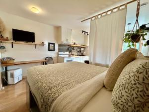 a small bedroom with a bed and a kitchen at Le Chalet Waterfront Studio Suite, View, Patio, Kitchen in Ucluelet