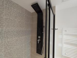 a shower with a black shower head in a bathroom at Chez Mika in Linxe